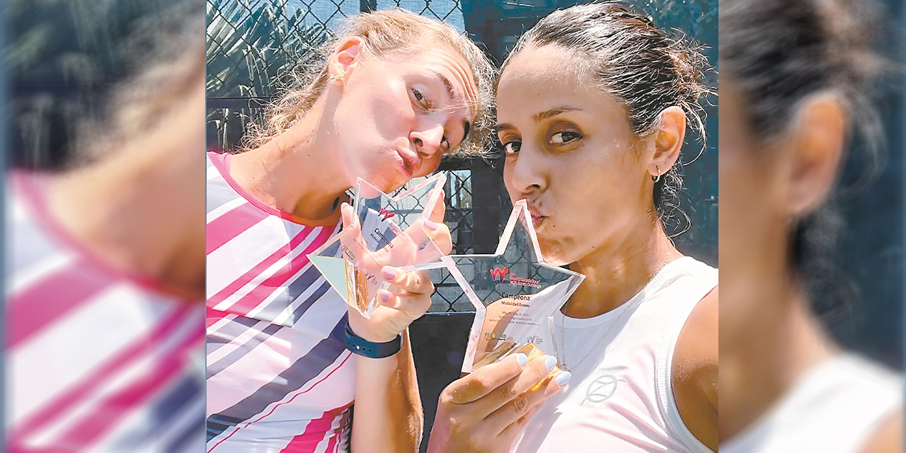 Noelia Zeballos (der.) y su compañera Marian Tona disfrutan del trofeo ganado.