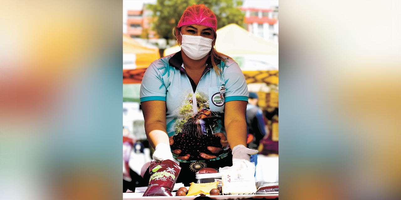Una mujer junto a su emprendimiento productivo.