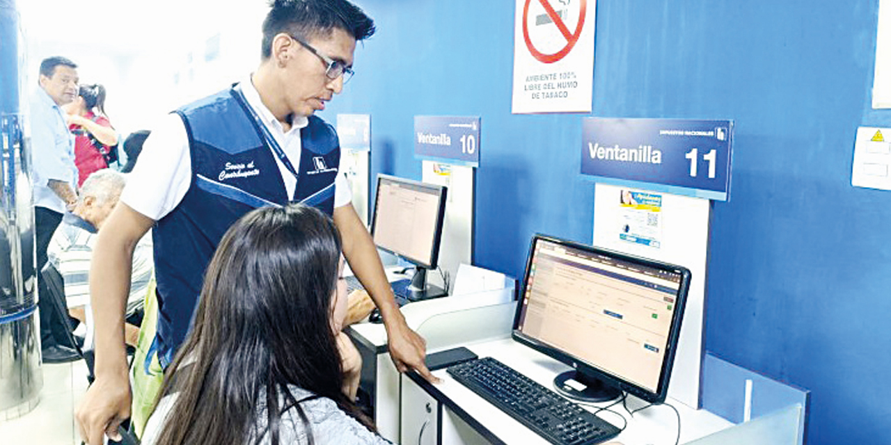 Un funcionario colabora con una contribuyente en el pago de impuestos de manera virtual.