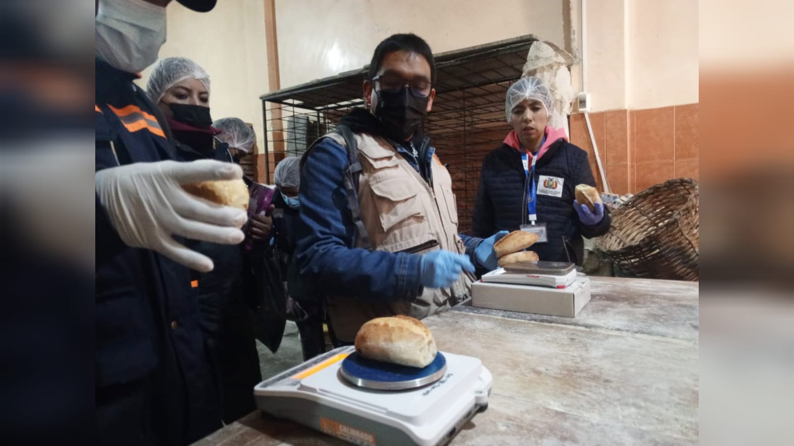 Personal de Ibmetro realiza el pesaje del pan en un horno. 