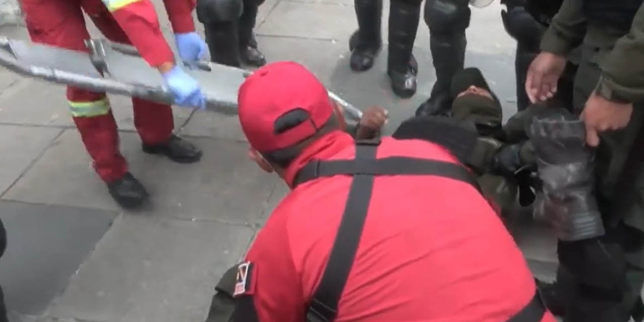 Un bombero auxilia a uno de los policías heridos por el ataque evista en La Paz. Foto: Captura DTV