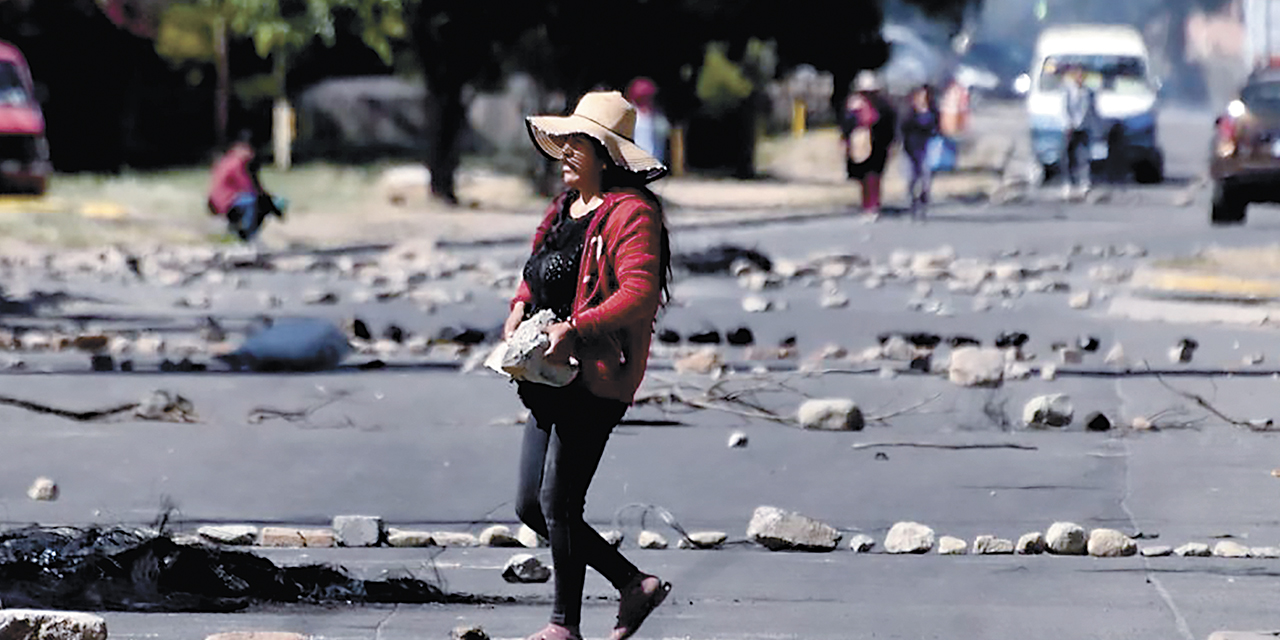 Una mujer desbloquea una ruta en Cochabamba.