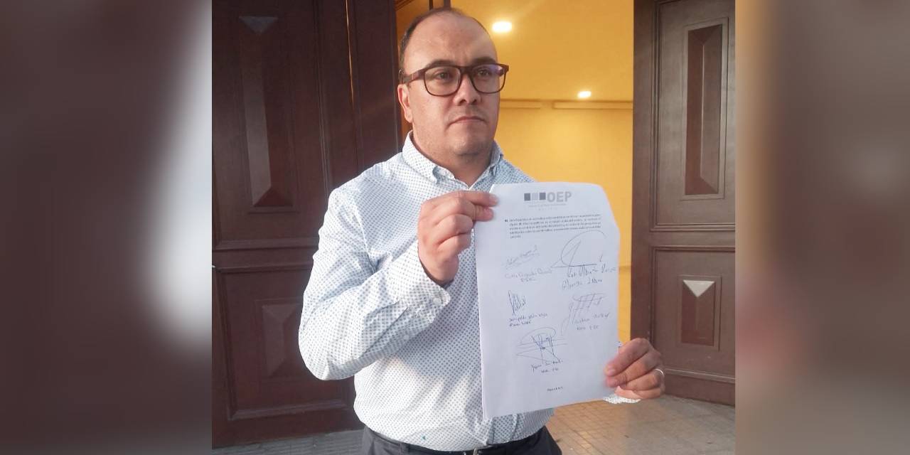 El vocal del Tribunal Supremo Electoral (TSE), Gustavo Ávila, muestra el documento firmado por los delegados de Libre y PDC. Foto: DTV