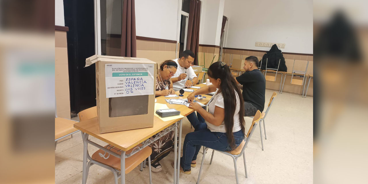 Ciudadanos bolivianos preparan su recinto electoral en Valencia, España.