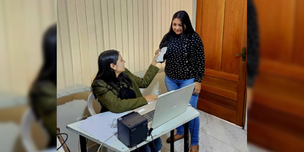 Una funcionaria del TED de Pando entrega el certificado de exención a una ciudadana.