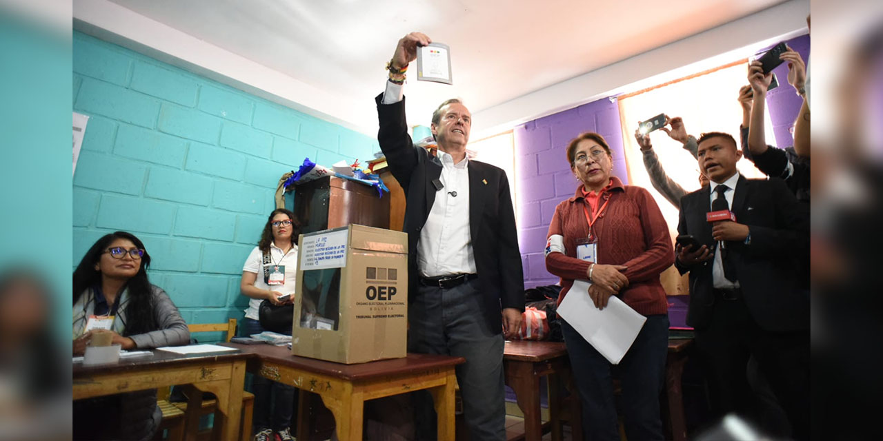 Jorge Tuto Quiroga muestra a la prensa la papeleta de sufragio antes de depositarla en la urna.