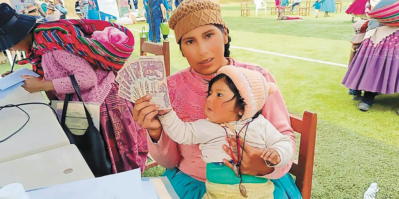 Una madre con su pequeño cobra el subsidio en Chuquisaca.