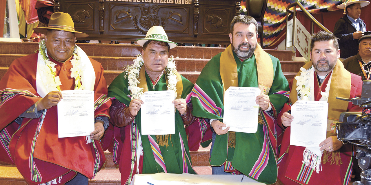 El ministro de Medio Ambiente, Álvaro Ruiz, y autoridades originarias muestran los convenios.