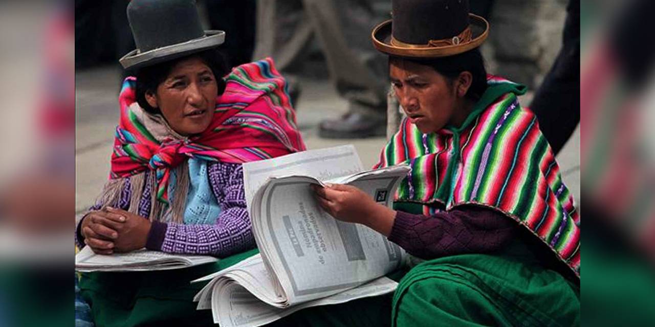 Mujeres aymaras con una publicación en castellano. Foto RRSS