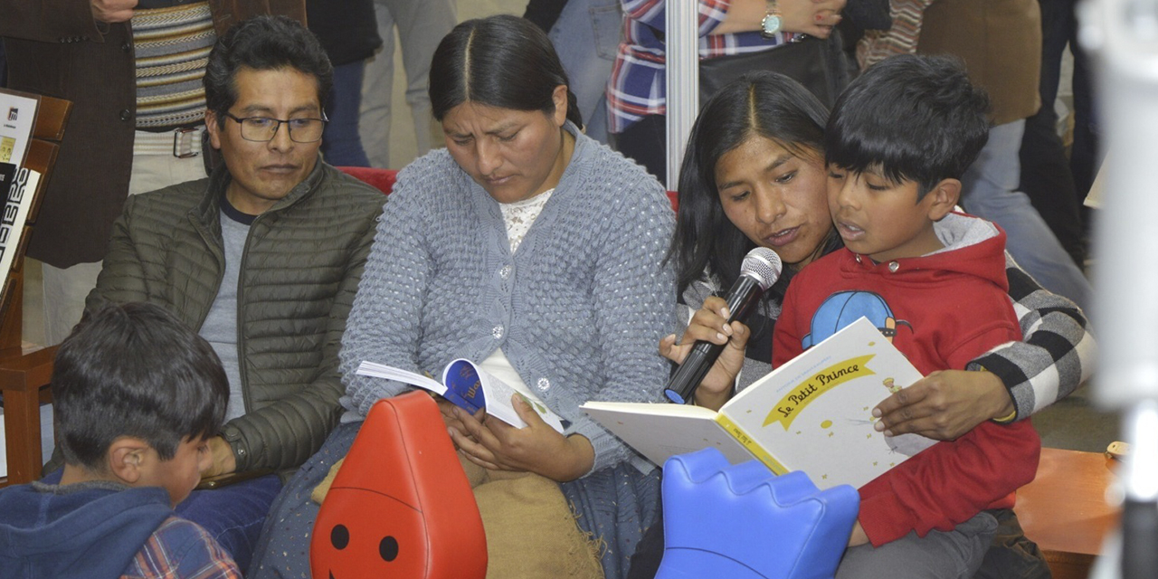 Un niño lee parte de la edición de El Principito. 