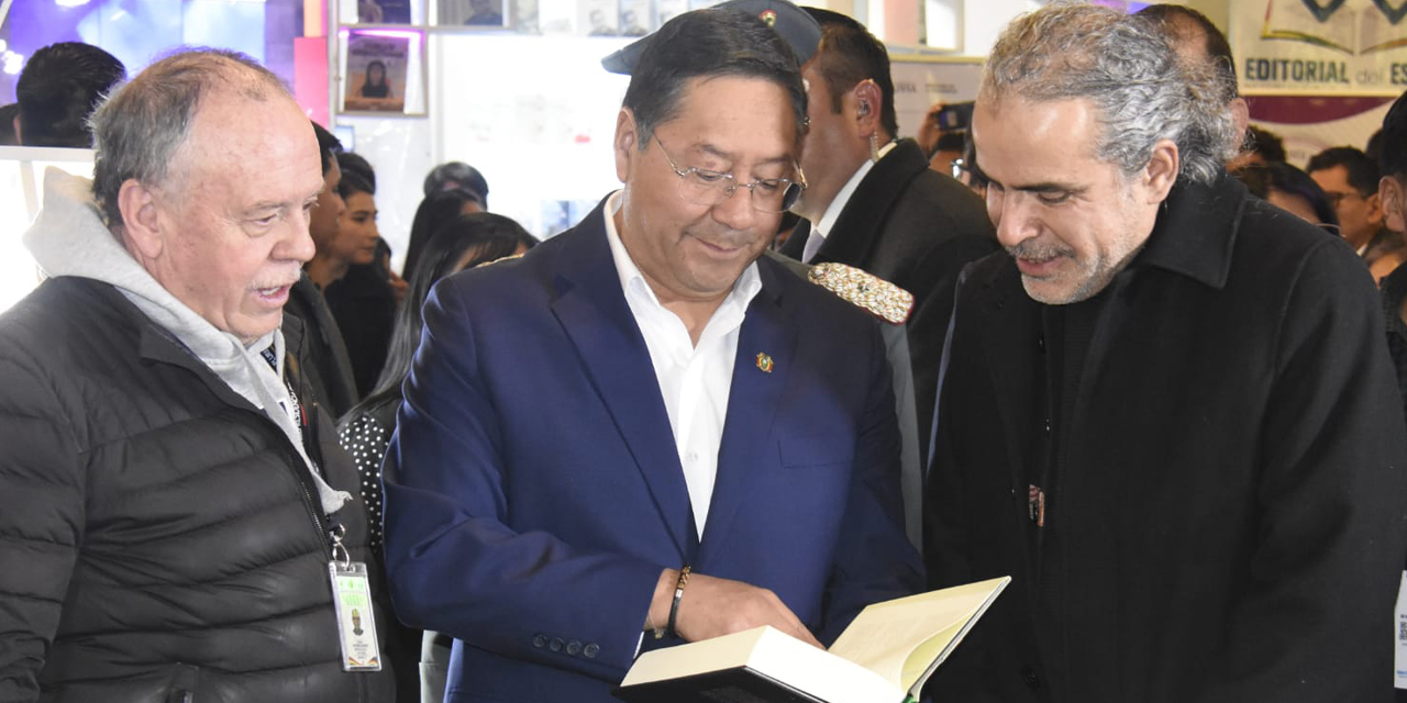 El presidente Luis Arce (centro) revisa uno de los varios libros que se exponen en la feria. | Foto: Gonzalo Jallasi