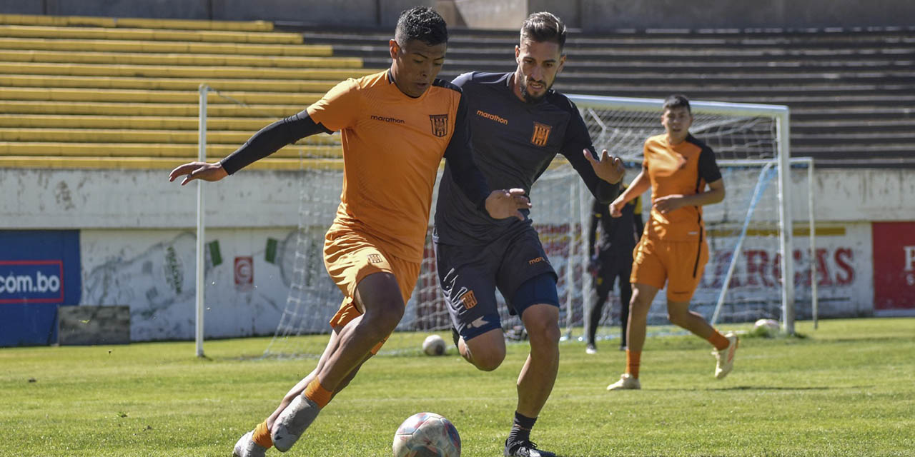 Ronald Bustos y Luciano Ursino disputan la posesión del balón en la práctica de fútbol del Tigre, en Achumani.