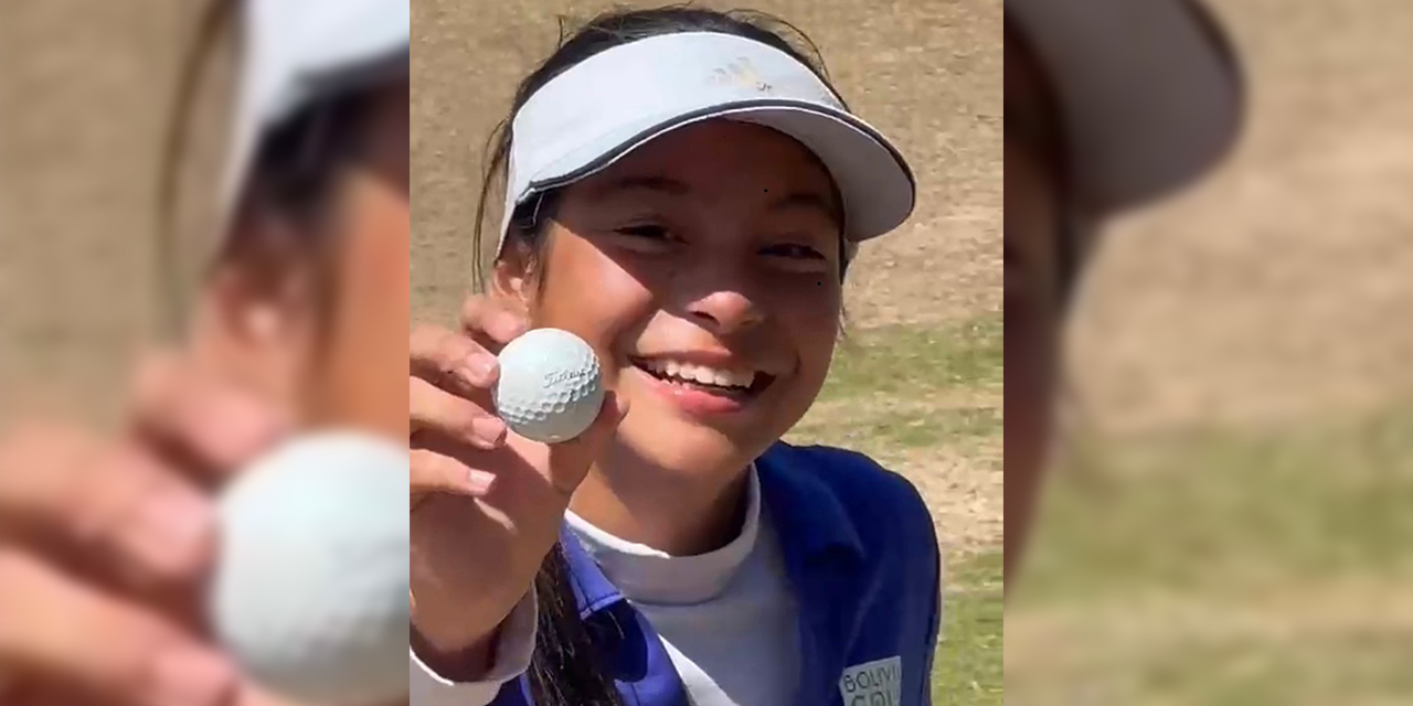 La golfista Onishi muestra orgullosa la bola con la que hizo hoyo en uno.