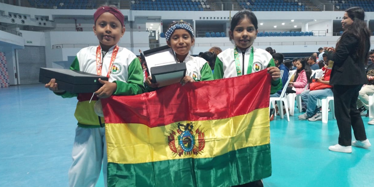 Las ajedrecistas que ganaron medallas para el país posan con la bandera boliviana.