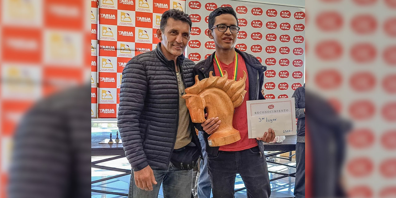 Daniel Titichoca (der.) exhibe orgulloso su trofeo y diploma del tercer lugar.