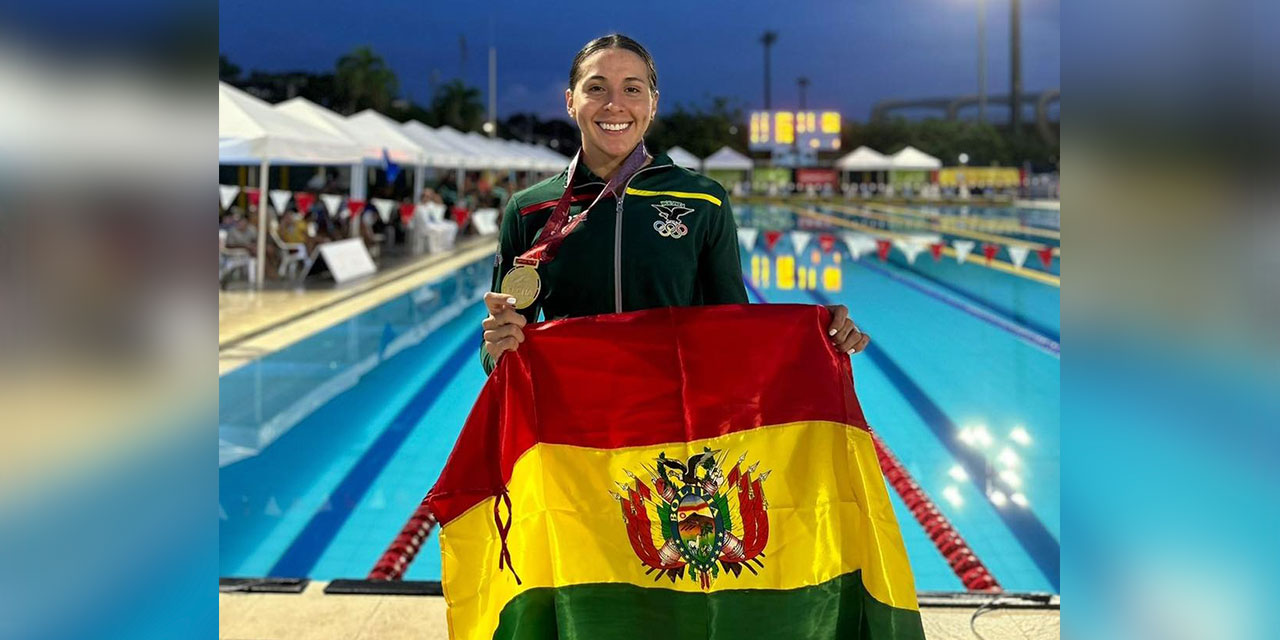 La nadadora Ribera posa orgullosa con la bandera nacional. Foto: FEBONA