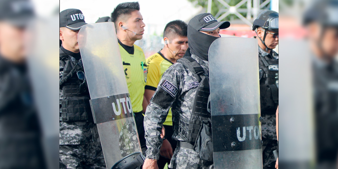 El árbitro Gabriel Mendoza abandona la cancha después de dar por finalizado el juego. Foto: APG