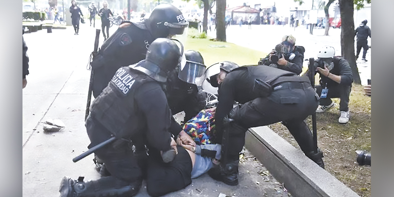 Un manifestante es detenido por policías en medio de las protestas. | Foto: RRSS