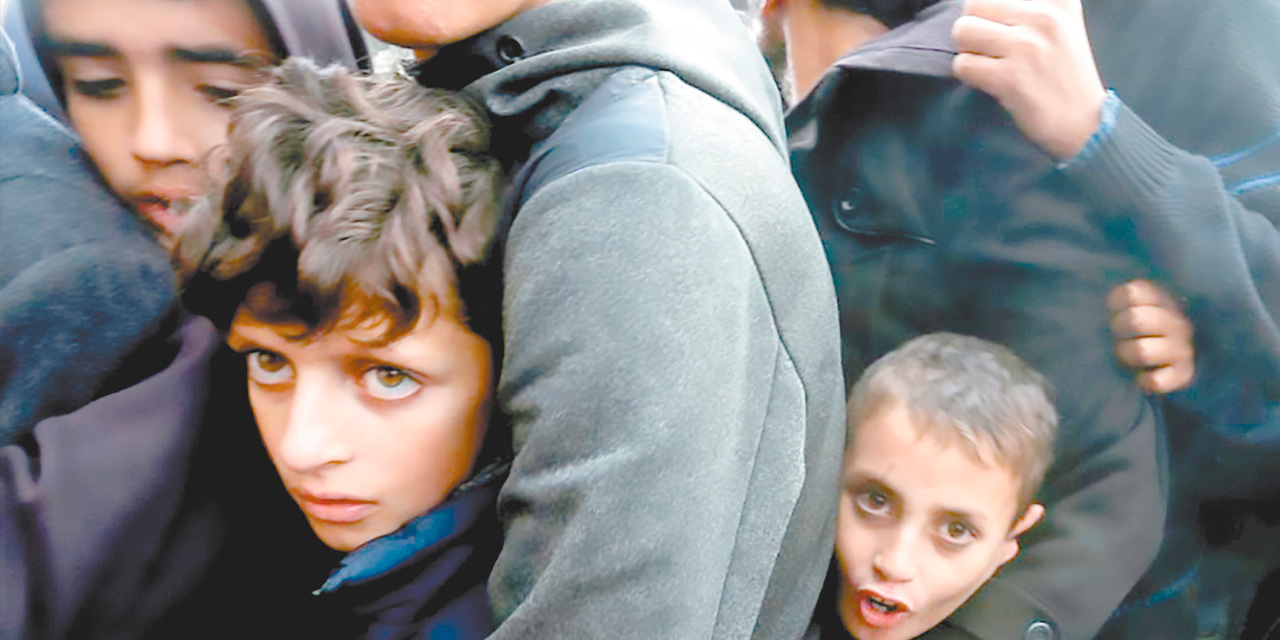 Niños y sus padres en una fila para recibir pan en Khan Younis, Gaza. Foto: ONU  