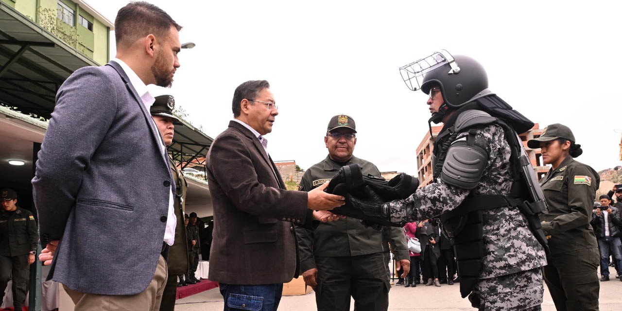 El Jefe de Estado, junto al ministro Del Castillo, hace entrega del equipamiento a un efectivo. | Foto: Jorge Mamani