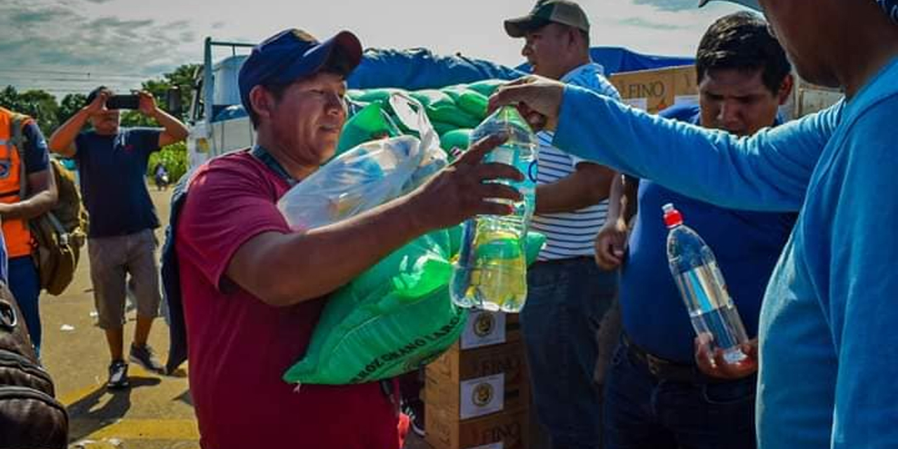 Un transportista recibe agua, aceite y arroz.