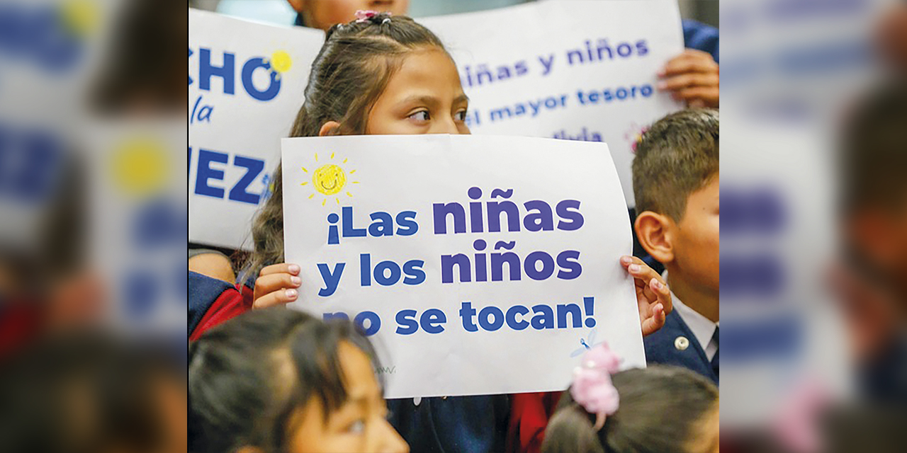 “Las niñas y niños no se tocan”, el cartel que una menor exhibe en la Casa Grande del Pueblo, ayer en La Paz. | Foto: Presidencia 