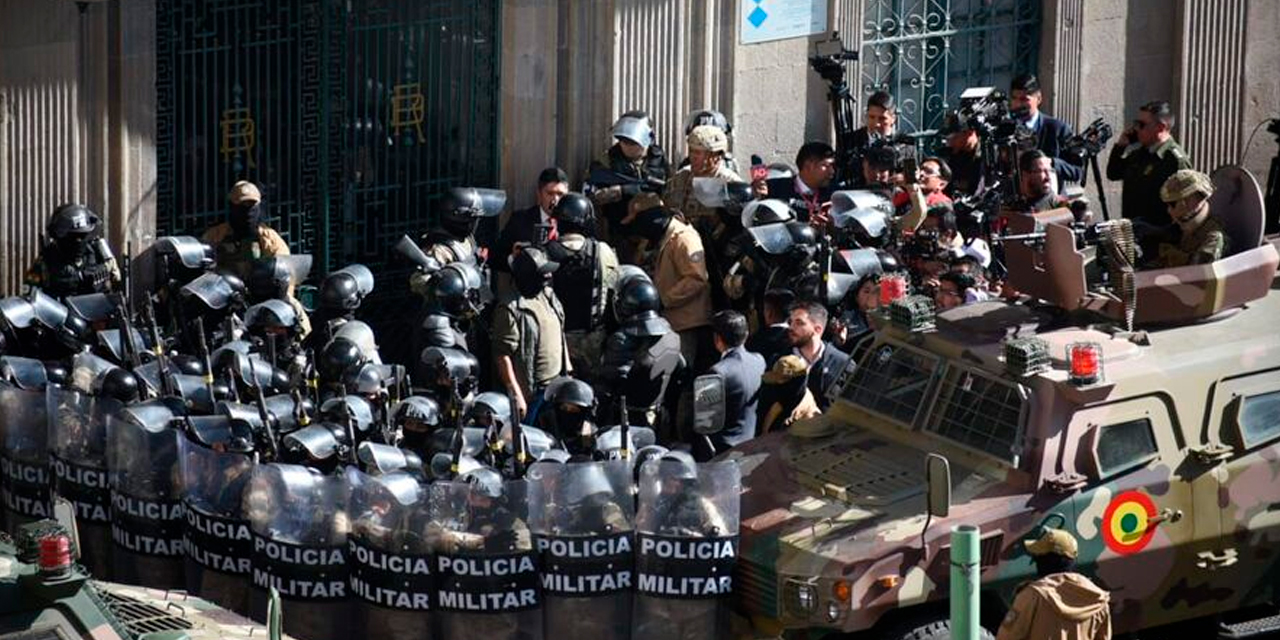 Una de las tanquetas y los uniformados de la Policía Militar en puertas de Palacio Quemado.