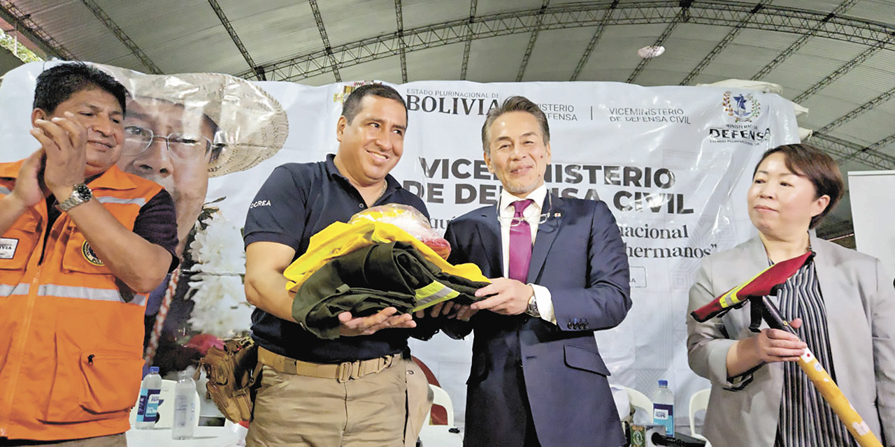 El embajador de Japón en Bolivia, Onomura Hiroshi, entrega equipamiento  a un bombero forestal de las  FFAA. | Foto: Defensa Civil