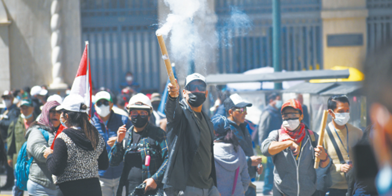 Maestros lanzan petardos durante la marcha de ayer.  (Foto: Gustavo Ticona)