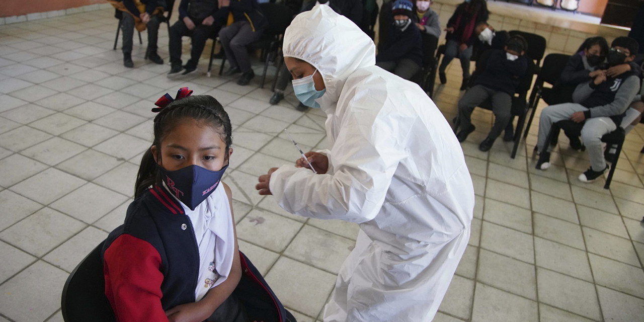 Personal de salud y niños en edad escolar con barbijos durante la campaña de vacunación contra el Covid-19. (Foto: Jorge Mamani)