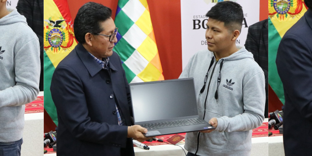 José Ernesto García recibe del ministro Edgar Pary una laptop. | Foto: Min. Educación