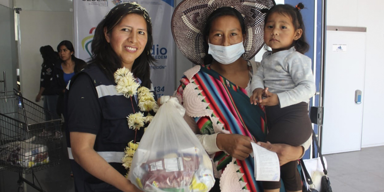 Una madre recibe su paquete de subsidio en Vinto.