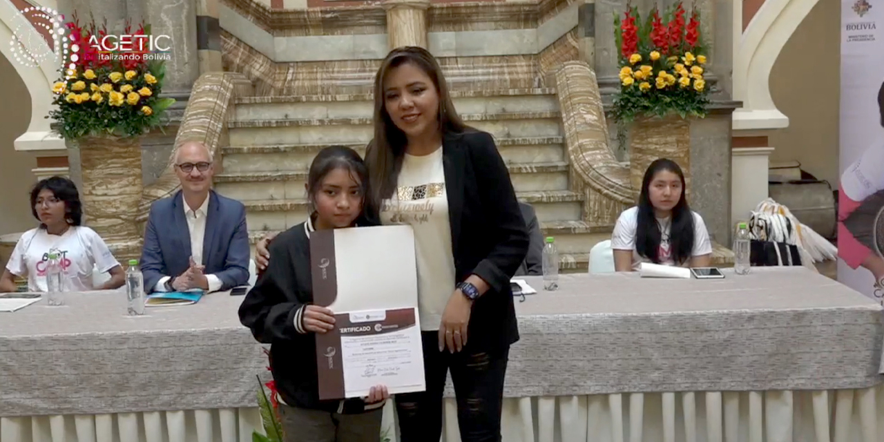 Una de las graduadas recibe su certificado de manos de la viceministra de Comunicación, Gabriela Alcón.