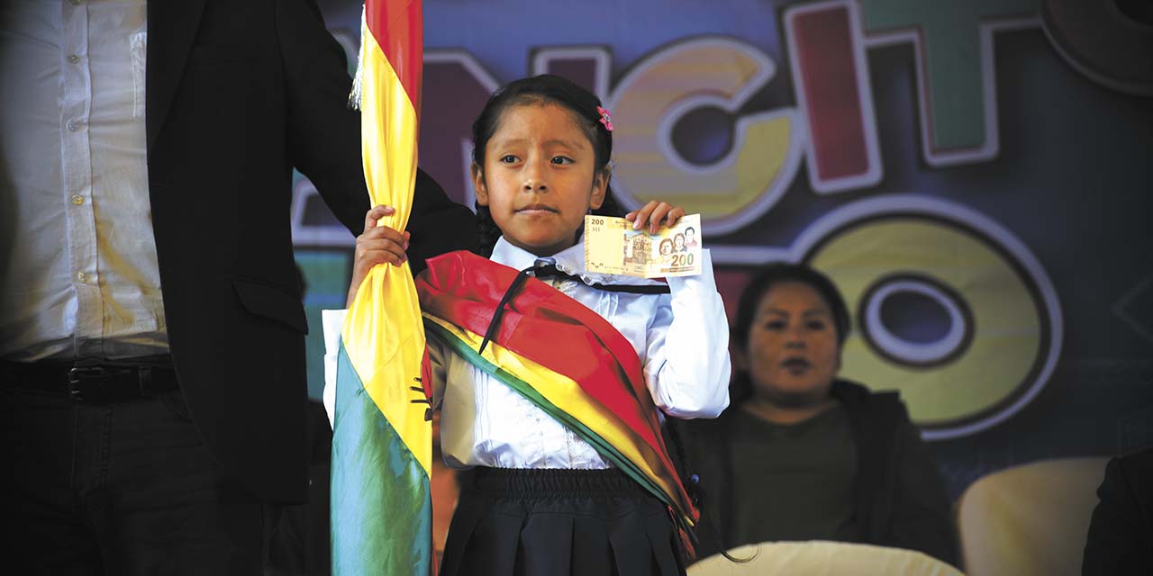 Una niña muestra el bono que recibió el lunes.  | Foto: Gustavo Ticona