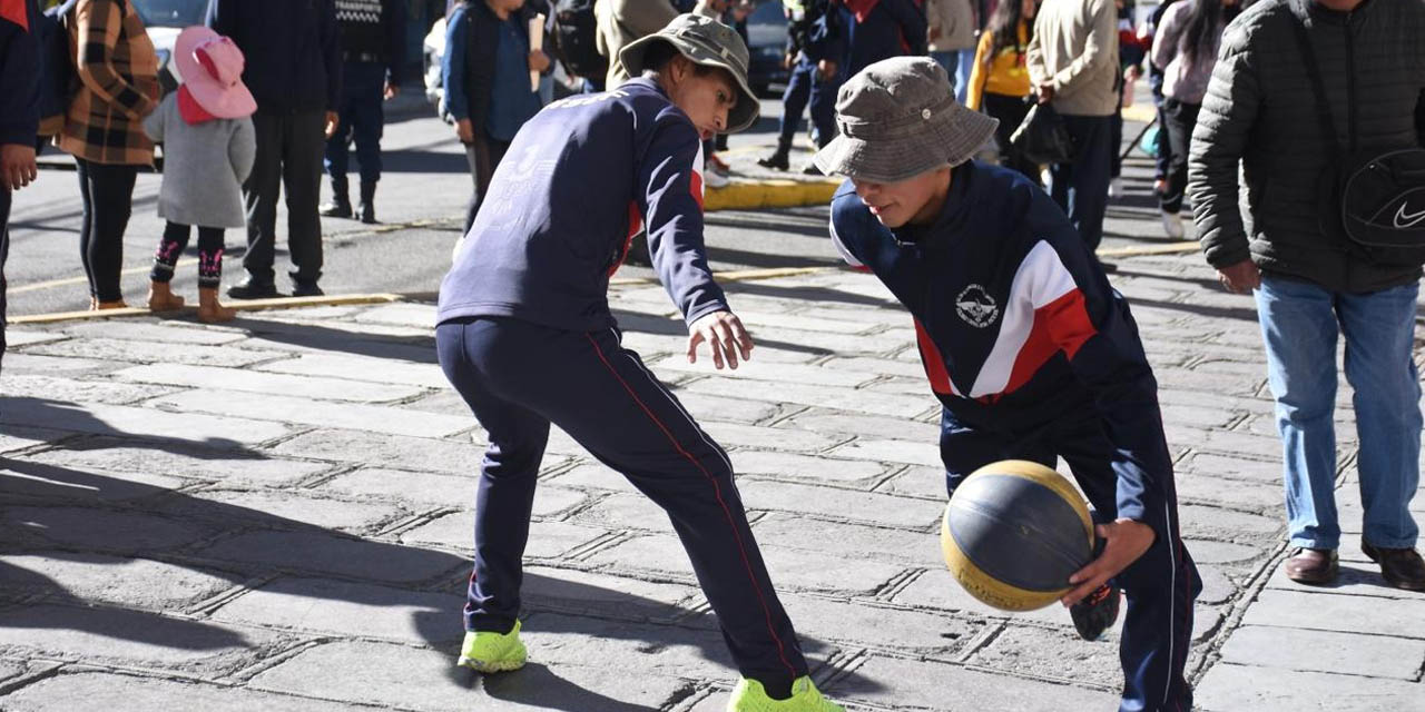 Dos estudiantes juegan basquetbol en las calles.  | Foto: Jorge Mamani