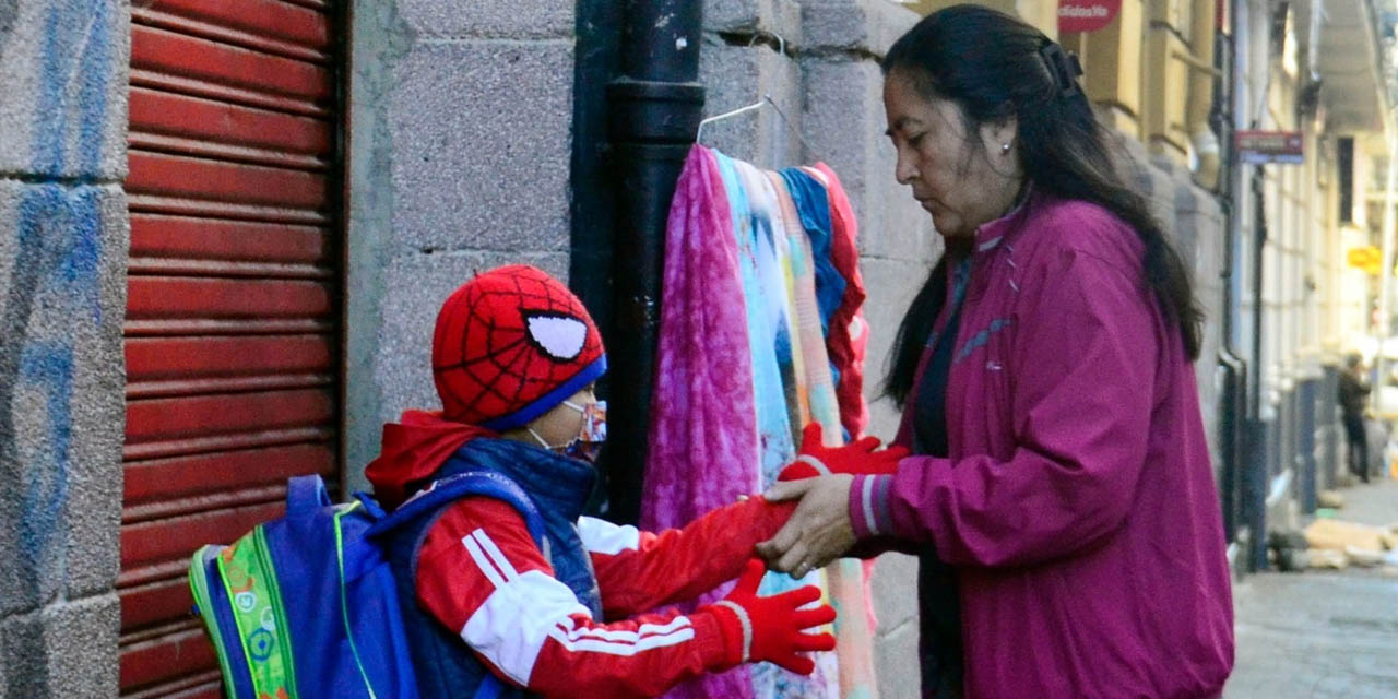 Una madre abriga a su hijo antes de ir al colegio.  | Foto: ABI