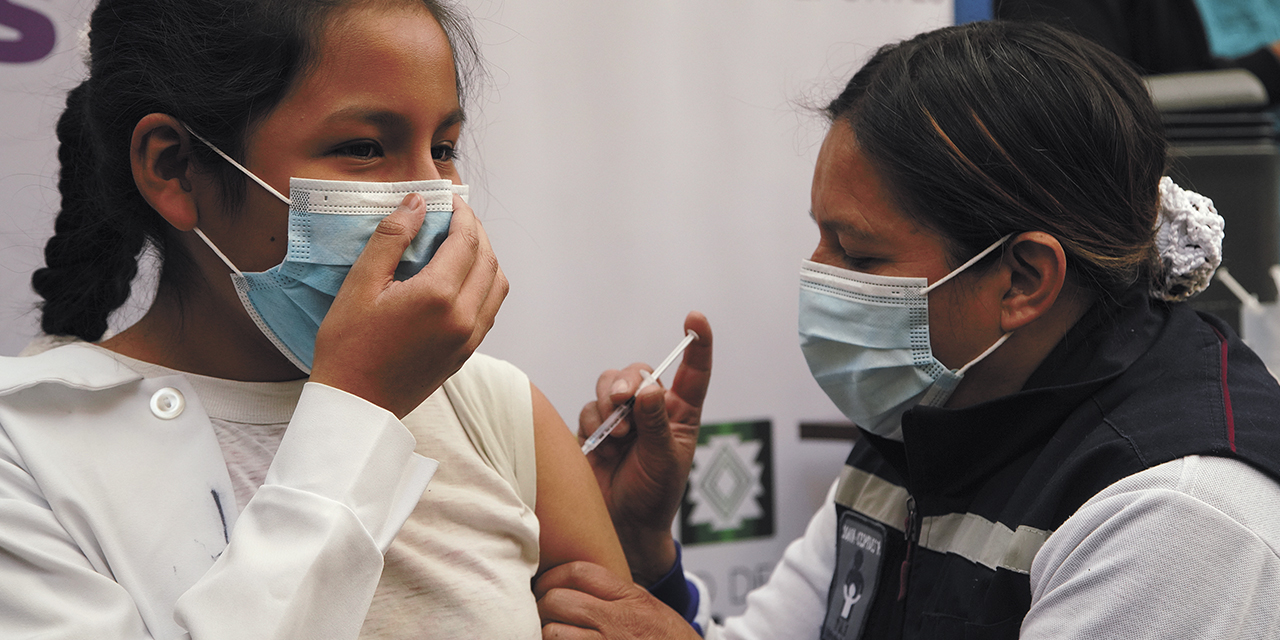 Personal en salud vacuna a una niña.