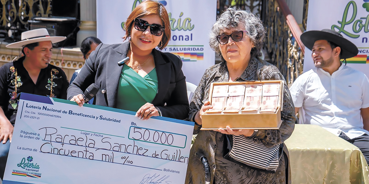 La esposa de Guido Alberto Guillén (der.) recibe el premio. | Foto: Lotería Nacional