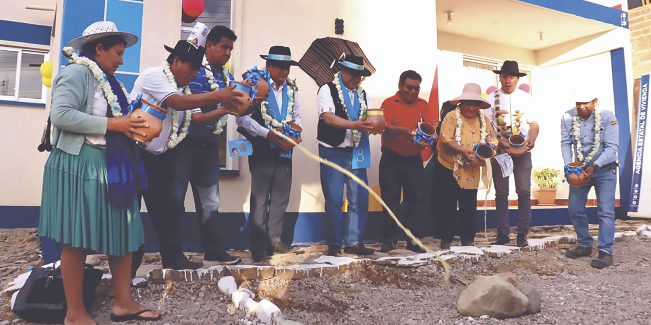 Autoridades y beneficiarios realizan la ch’alla de las viviendas.