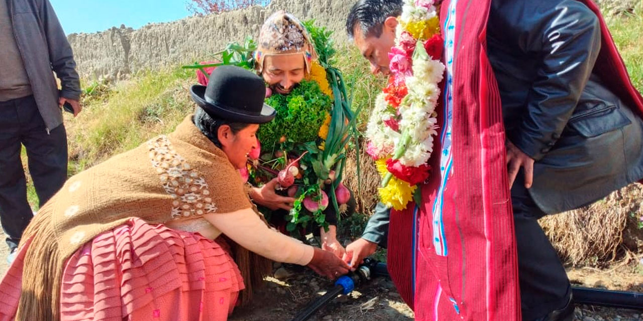 Una de las varias beneficiadas del sistema de riego por aspersión en la comunidad de Uypaca, Achocalla, junto a las autoridades. Foto: MDRyT