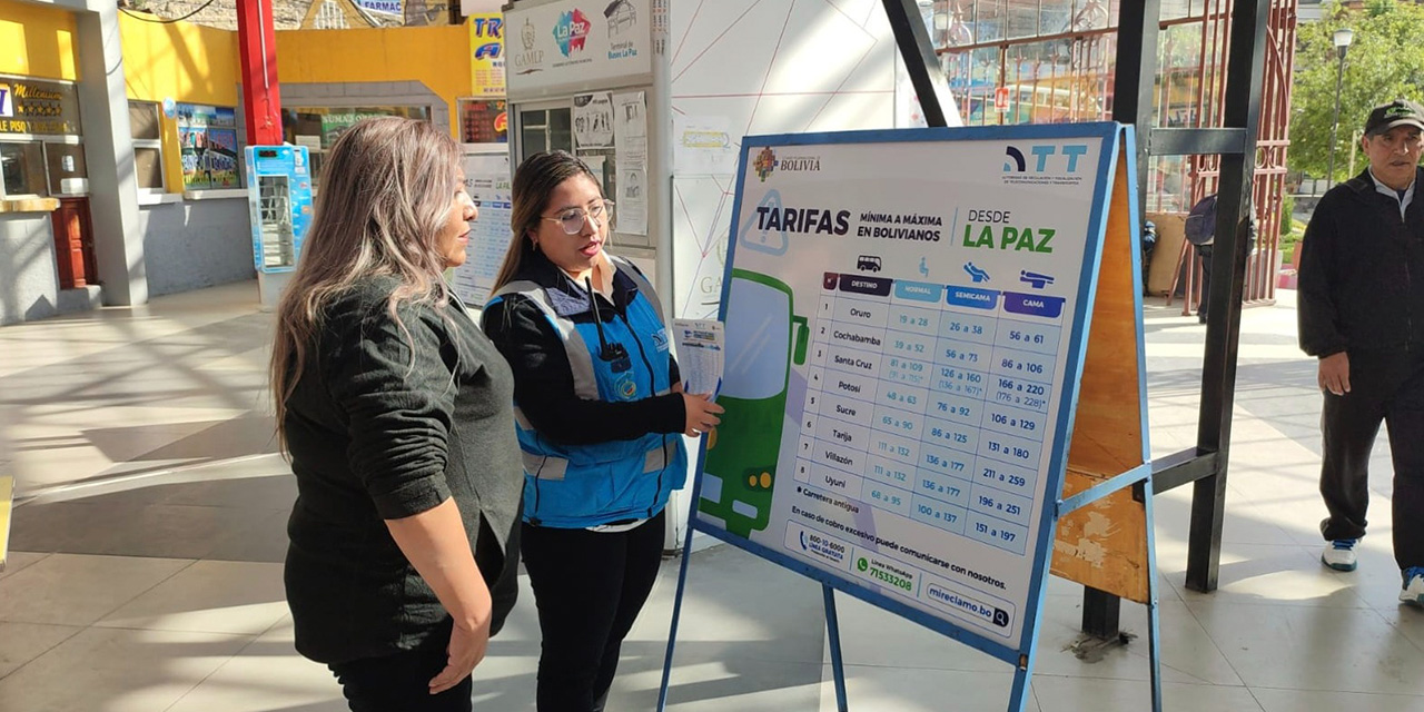 Personal de la ATT le explica las tarifas autorizadas a una pasajera en la terminal de La Paz. Foto: ATT