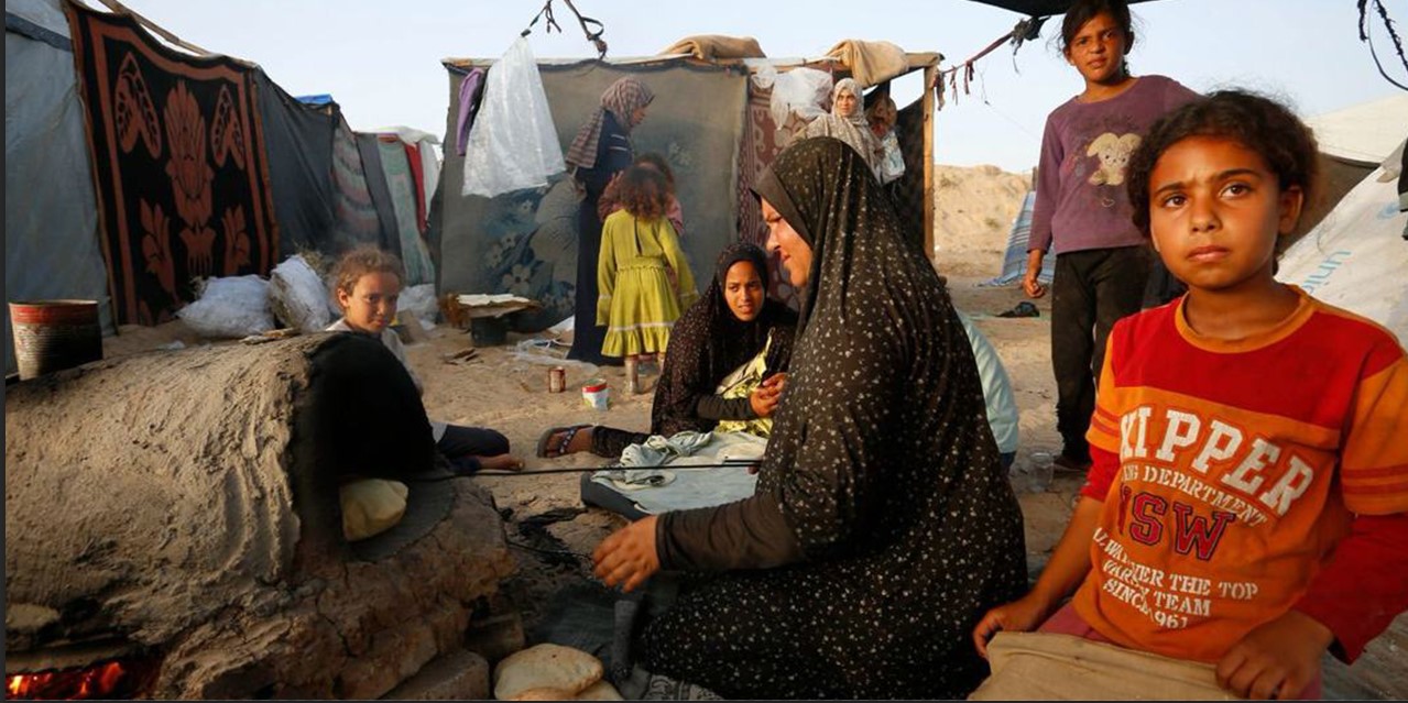 Una mujer cocina pan en un horno en la Franja de Gaza. Foto NNUU