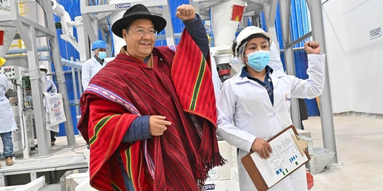 El presidente Luis Arce junto a una funcionaria en la moderna planta de almacenamiento de trigo y producción de harina, en Viacha. | Foto: Presidencia