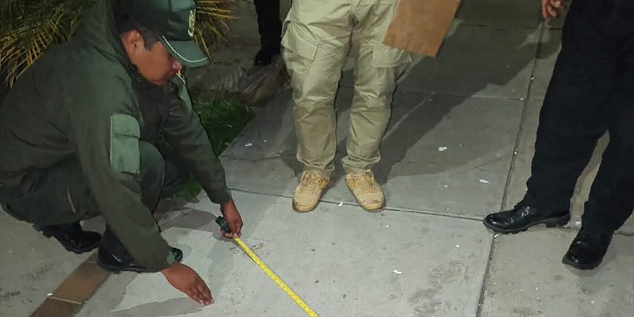 Efectivos policiales recogen restos del artefacto explosivo que causó zozobra en el domicilio del vocal Valenzuela del TED Cochabamba. 